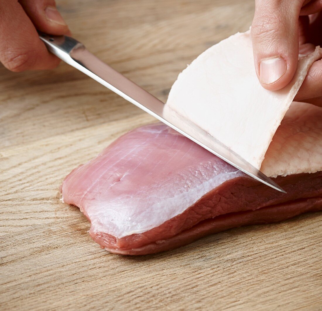 Skin being removed from a duck breast