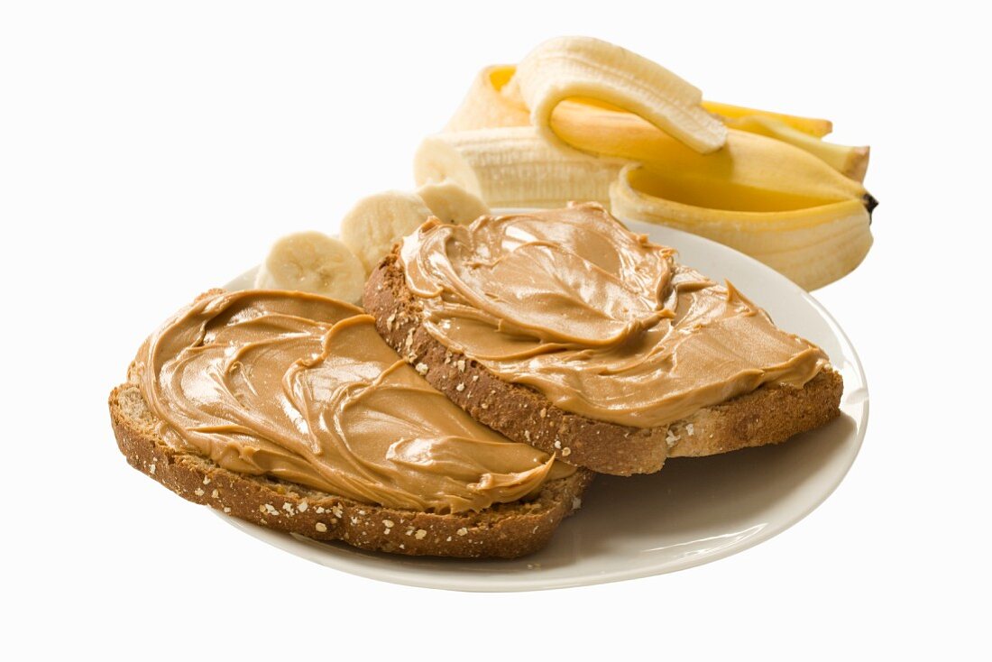 A banana and slices of bread spread with peanut butter