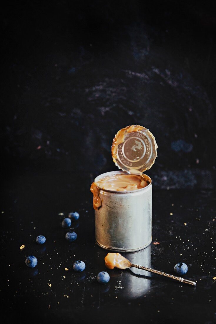 A tin of dulce de leche and blueberries