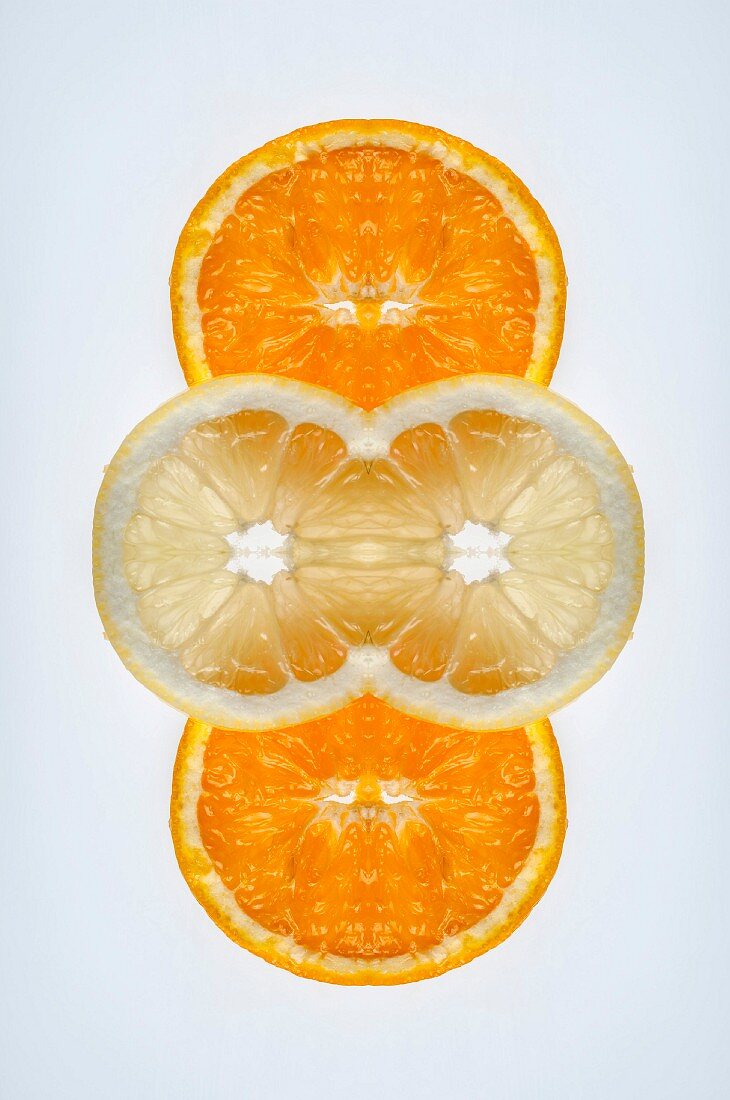 Digitale Komposition aus den Spiegelbildern von Orangen- und Zitronenscheiben
