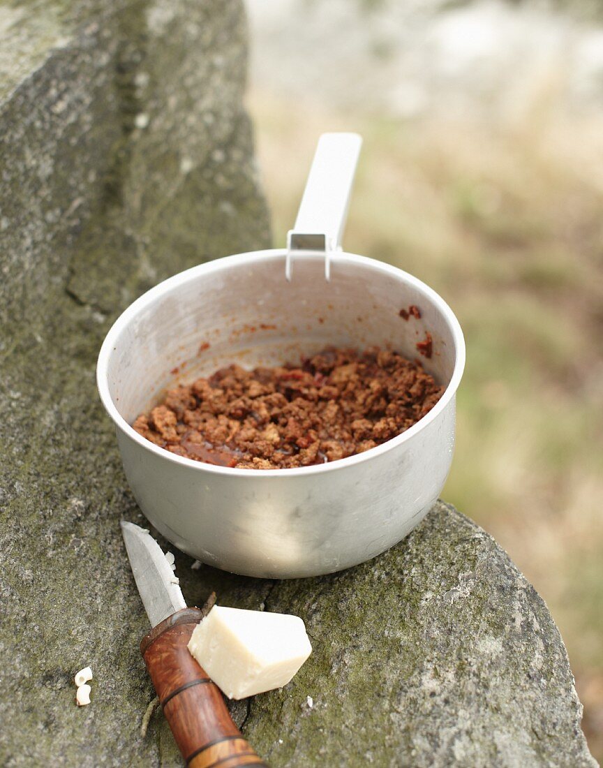 Bolognese sauce, a pocket knife and cheese for camping on a rocky ledge