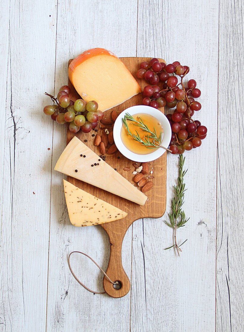 Käsebrett mit Trauben, Mandeln Olivenöl und Rosmarin