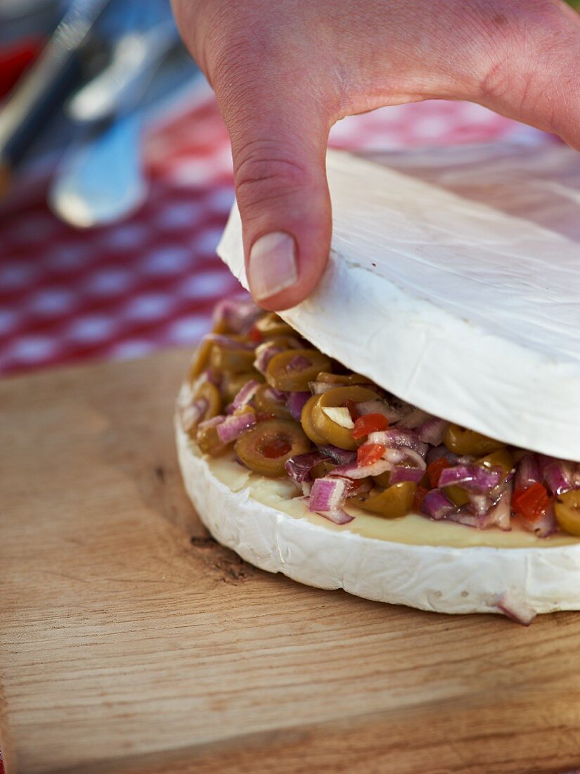 Gegrillte Brietorte mit Oliven und roten Zwiebeln