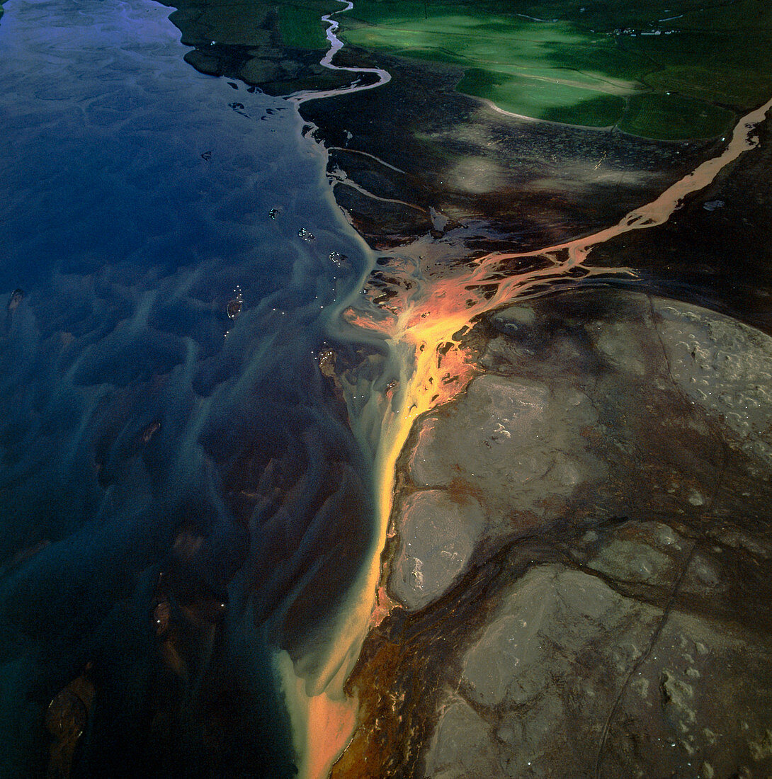 View of a coloured tributary flowing into a river