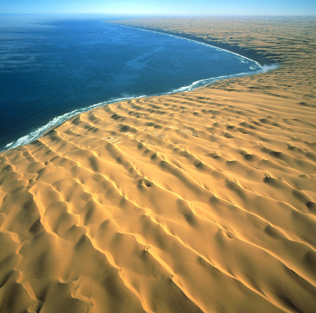 View of Namib desert dunes meeting the ocean