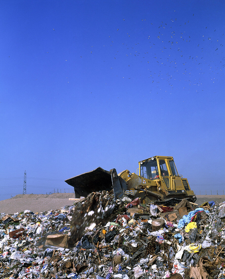Landfill site with bulldozer levelling refuse