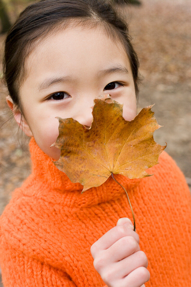 Girl holding an autumn leaf