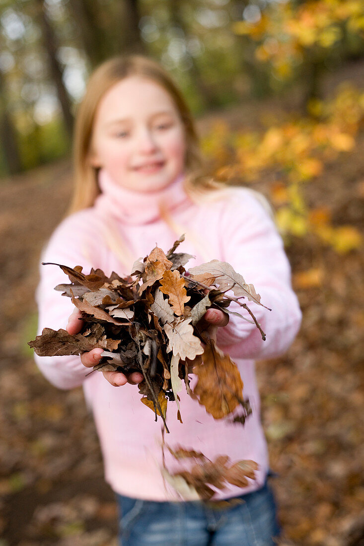 Girl holding autumn leaves