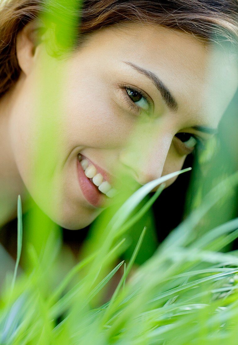 Woman smiling through grass