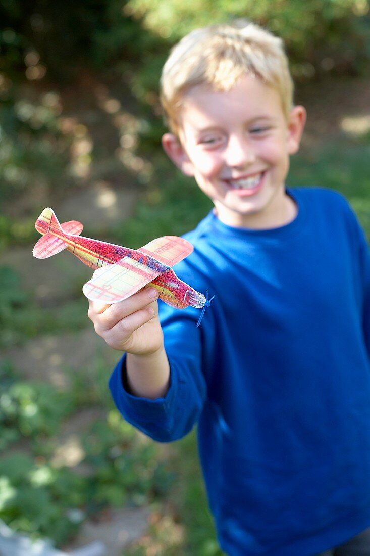 Boy playing with a toy aeroplane