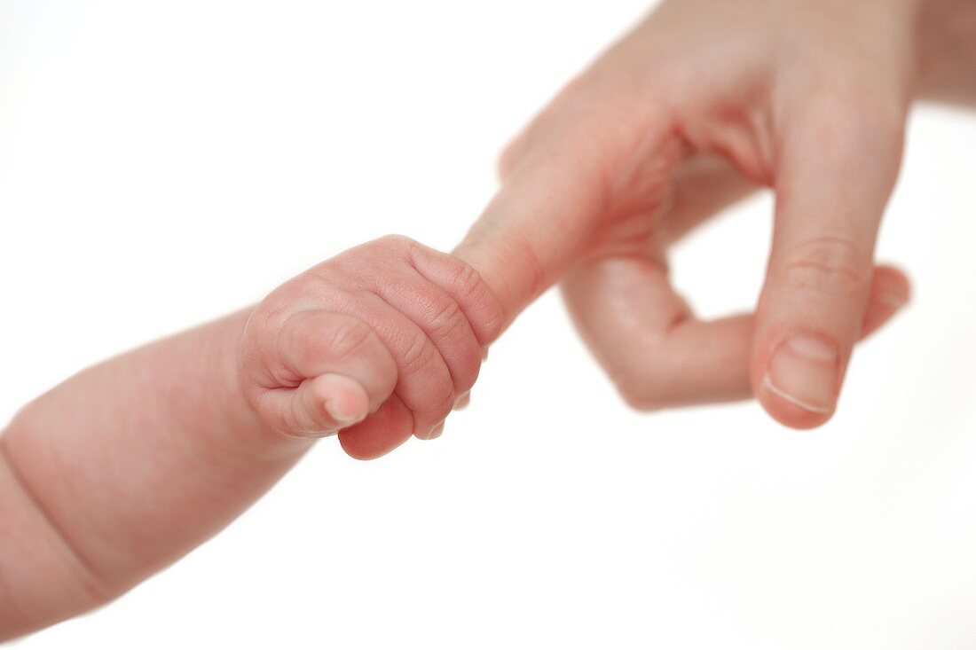 Baby holding her mother's finger