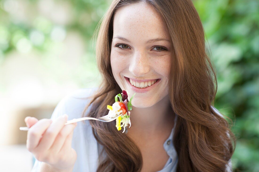 Young woman eating a salad