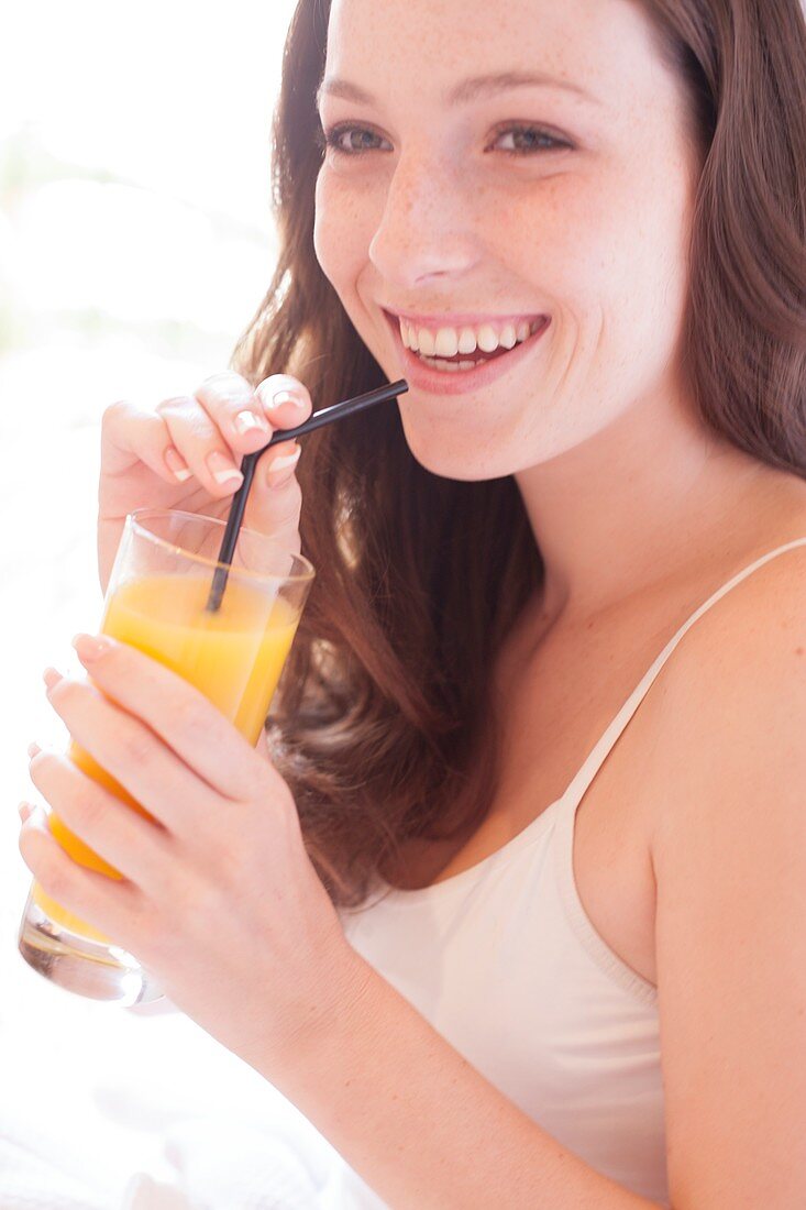 Young woman drinking fruit juice
