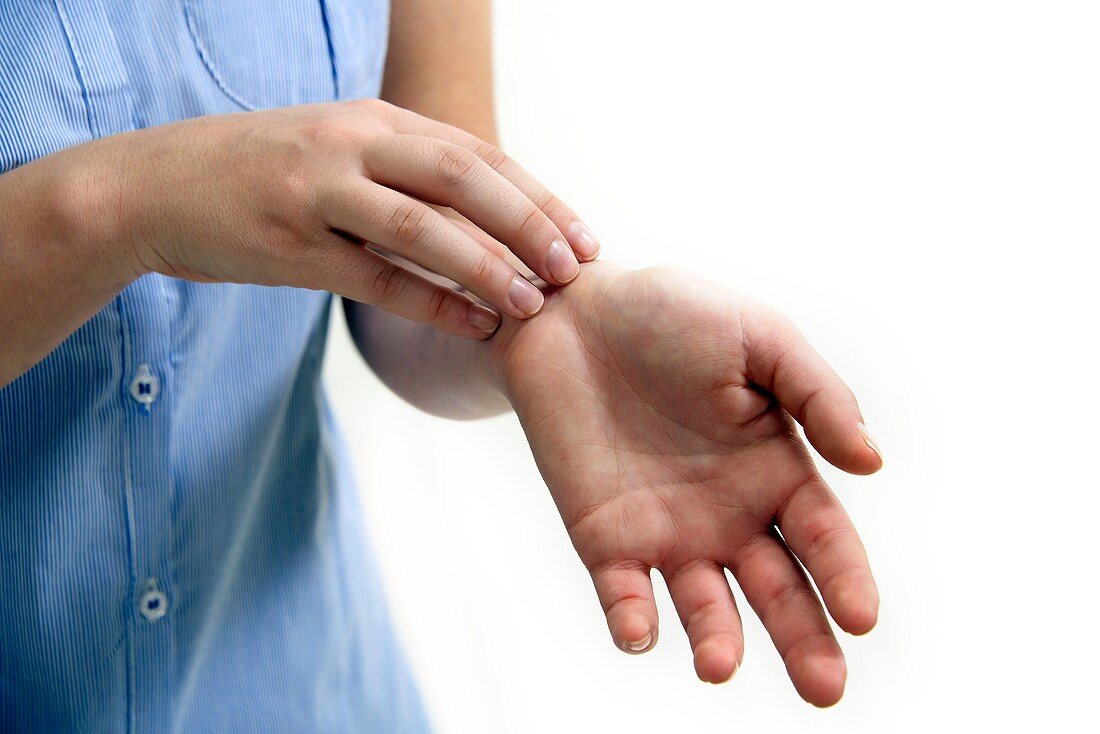 Teenage girl scratching wrist