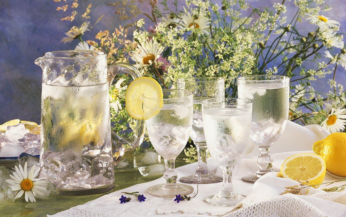 Krug und vier Gläser mit eisgekühltem Wasser