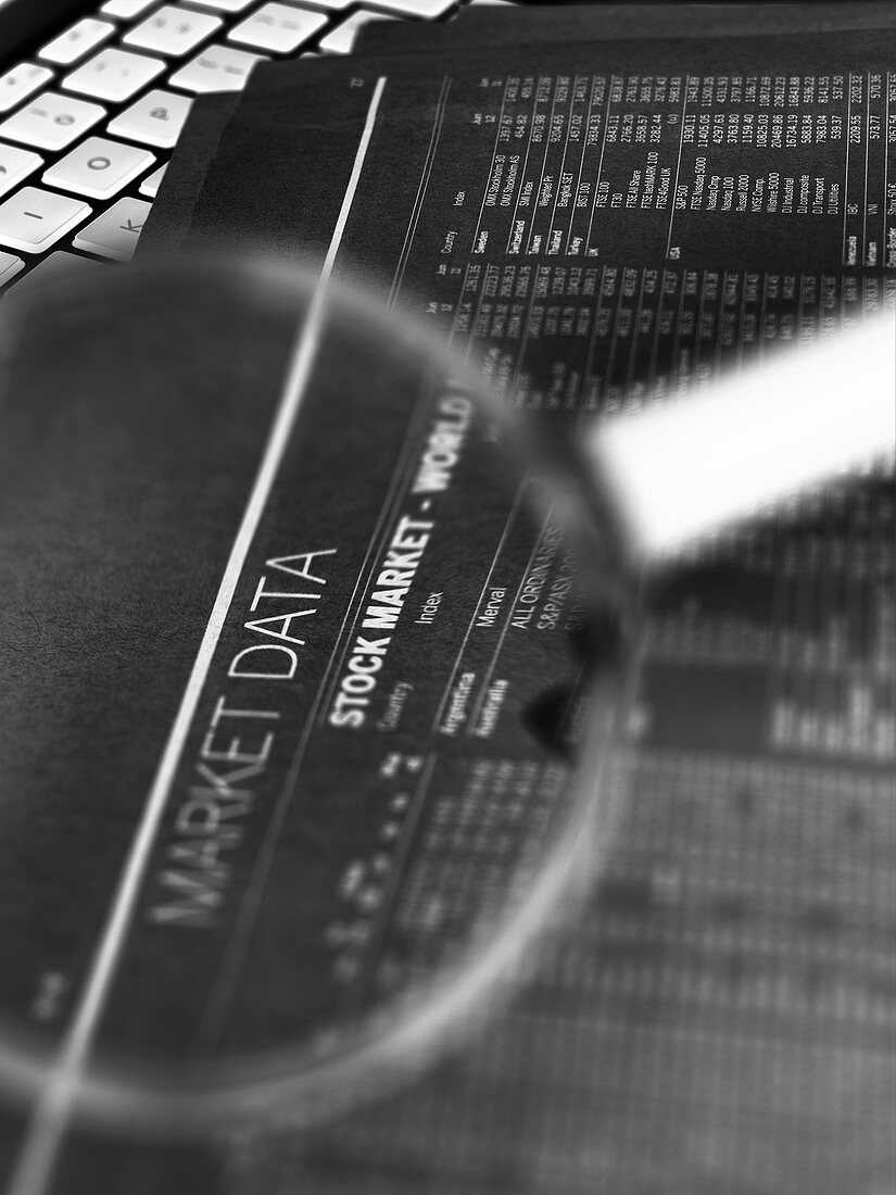 Stock market figures and magnifying glass