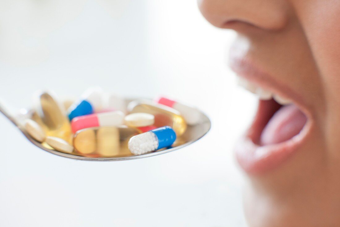 Woman and spoon of pills