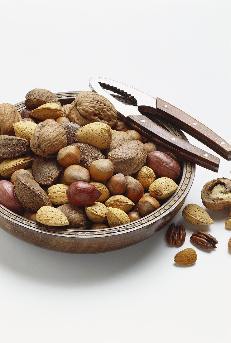 Various nuts and almonds in bowl with nut crackers