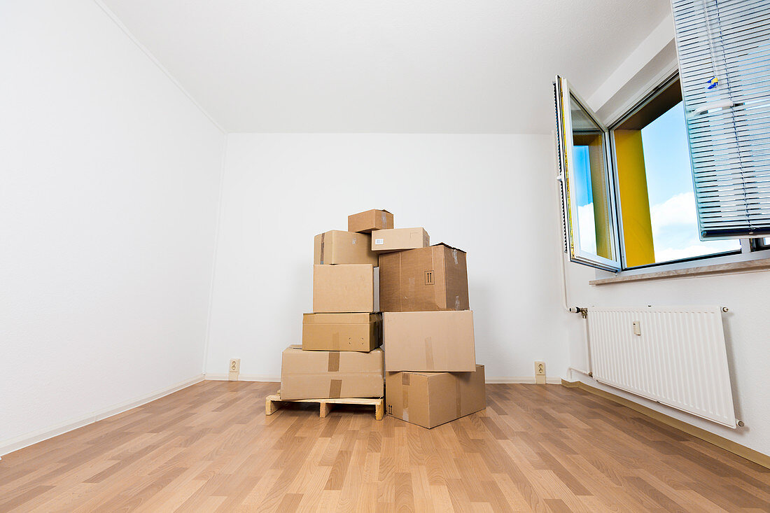 Stack of cardboard boxes in an empty room