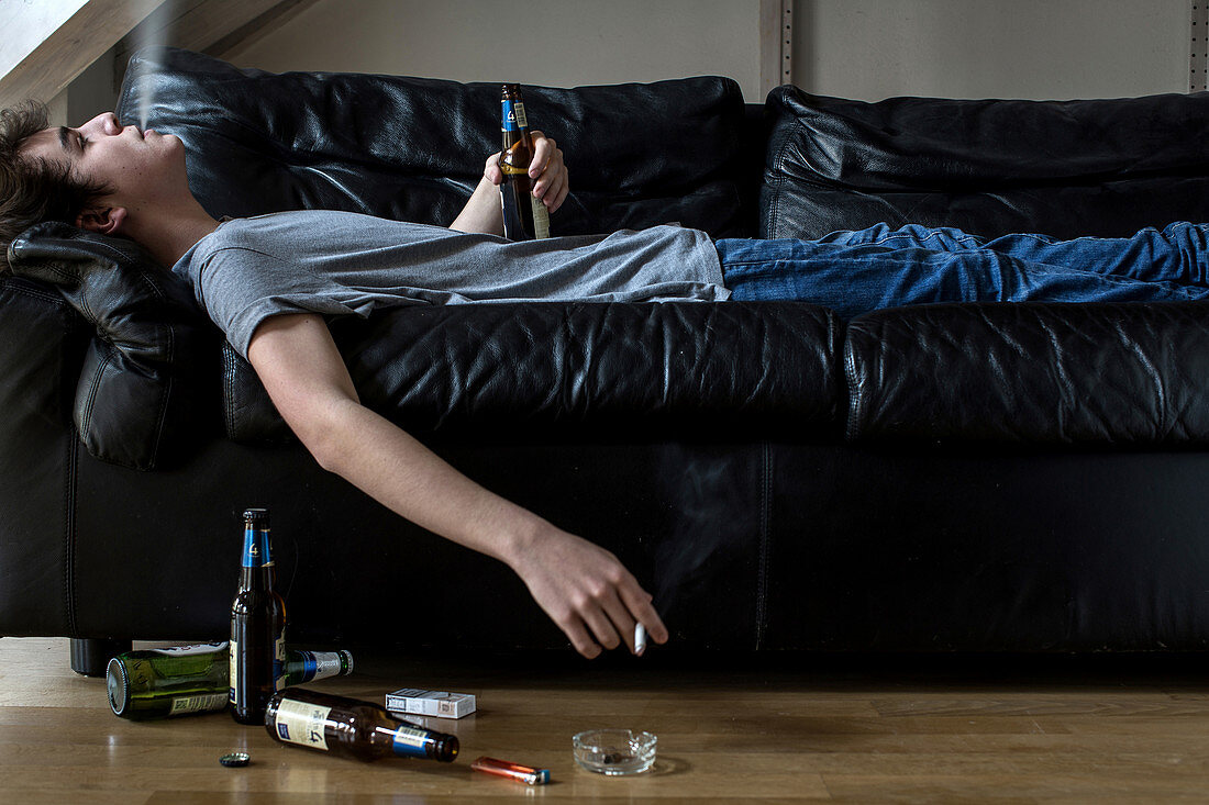 Young man holding beer,smoking