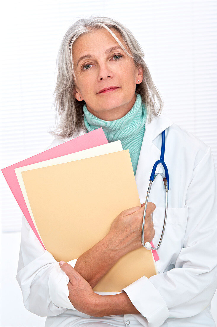 Mature female doctor holding files