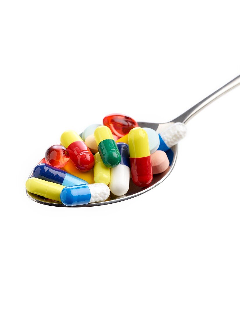 Spoon full of tablets and capsules