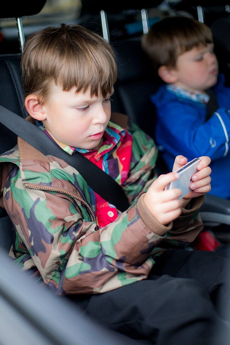 Boy in car using digital device