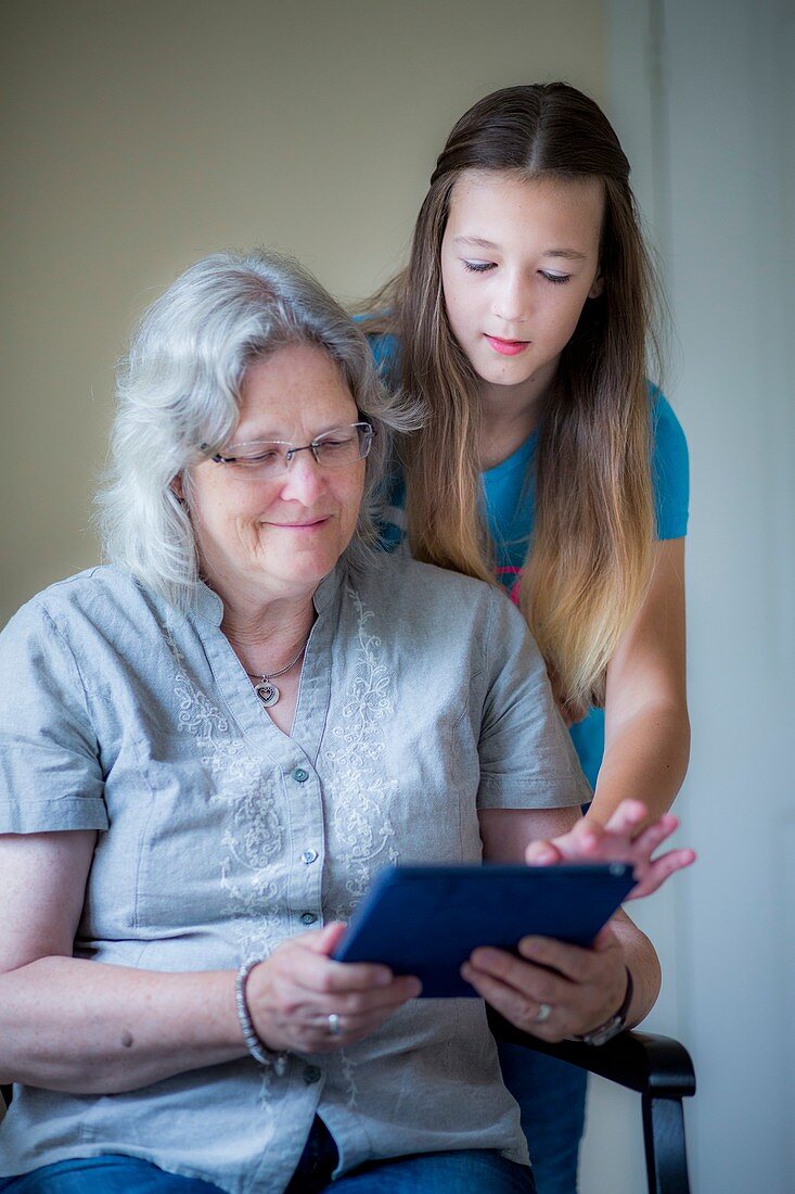 Girl and grandmother using tablet
