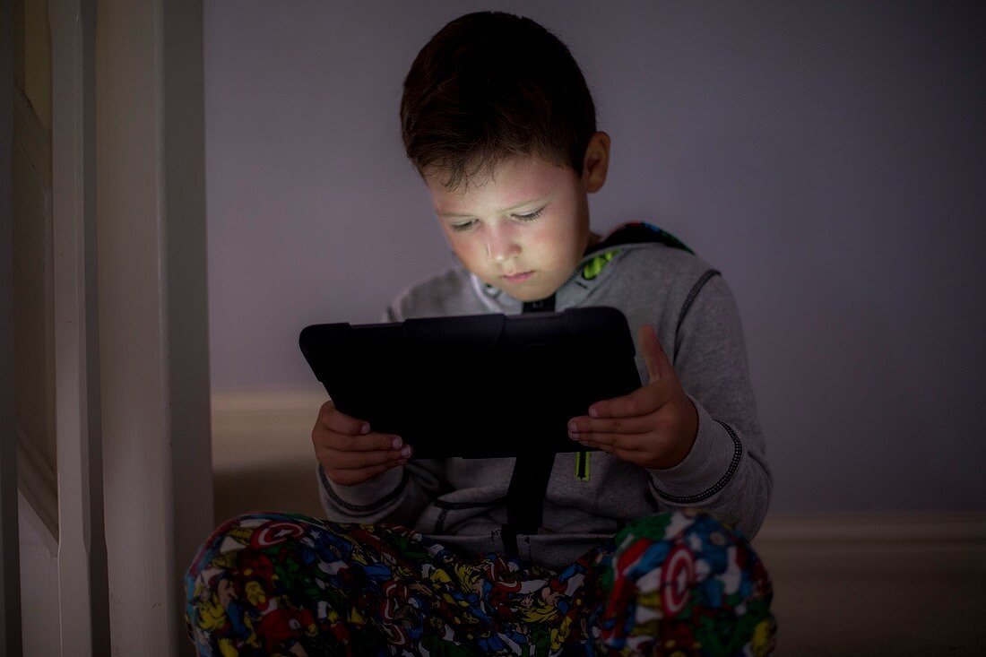 Boy using a digital tablet in the dark