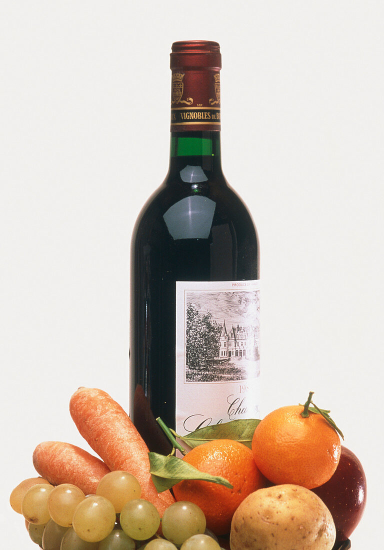 Bottle of red wine with fruit and vegetables