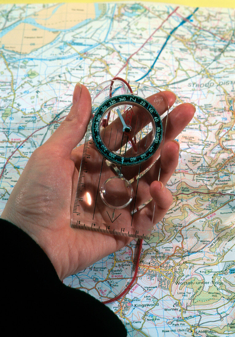 Person uses a magnetic compass and a map