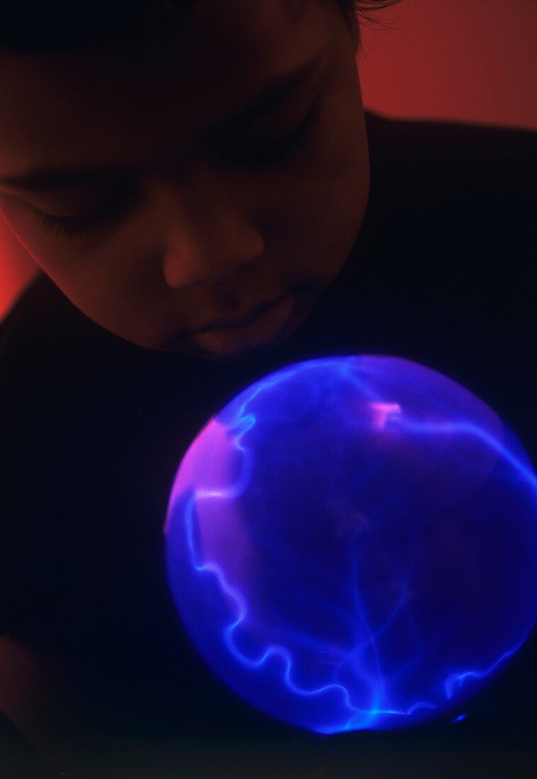 Boy watching a plasma globe