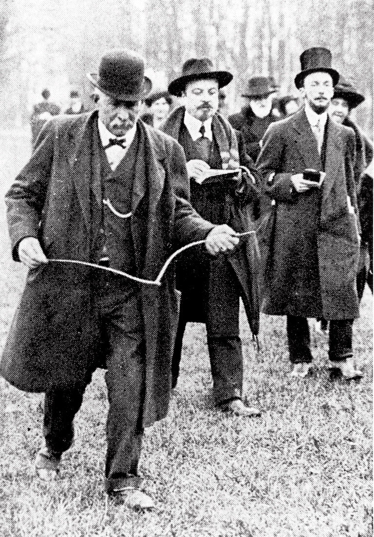 Man using a dowsing rod in the early 20th century