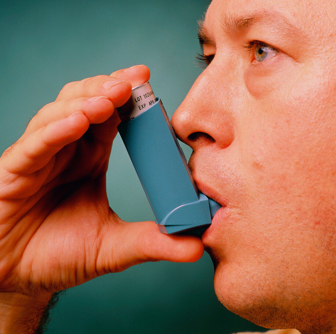 Man using Ventolin inhaler to control asthma