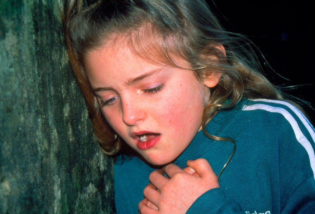 9 year old girl holding chest during asthma attack
