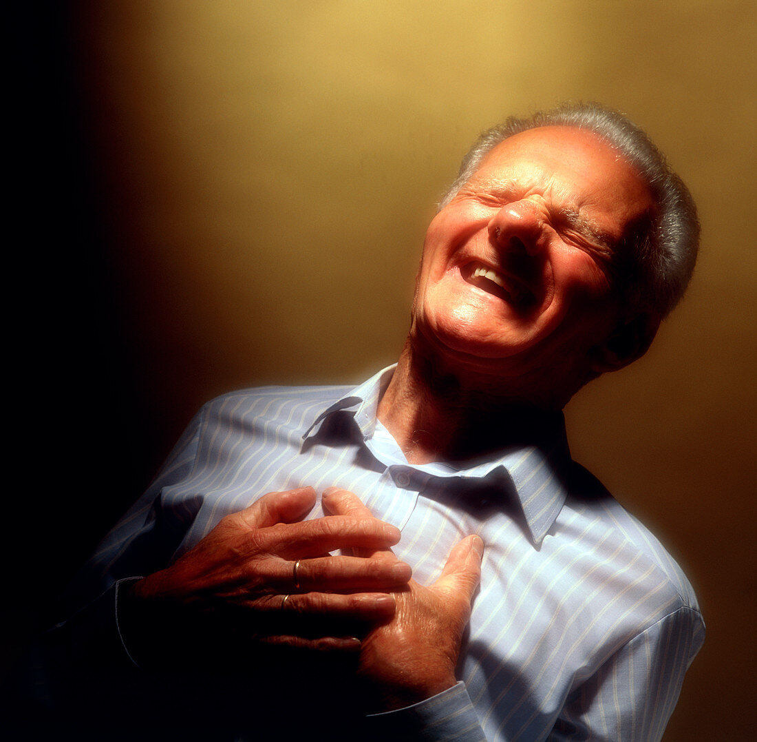 Man holds his chest due to angina or heart attack