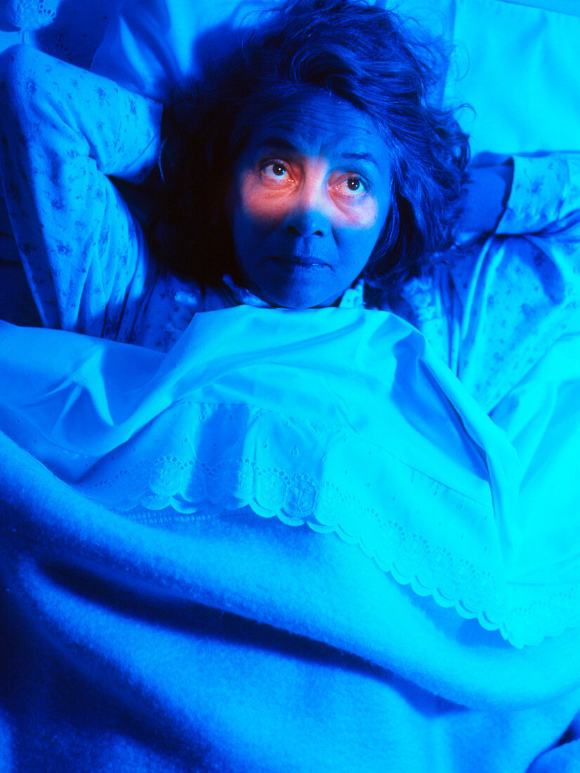 Insomnia: woman in bed unable to sleep