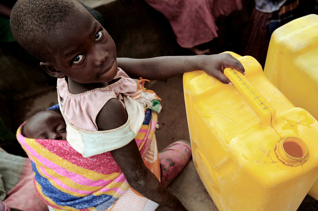 Refugee girl carrying a baby,Uganda