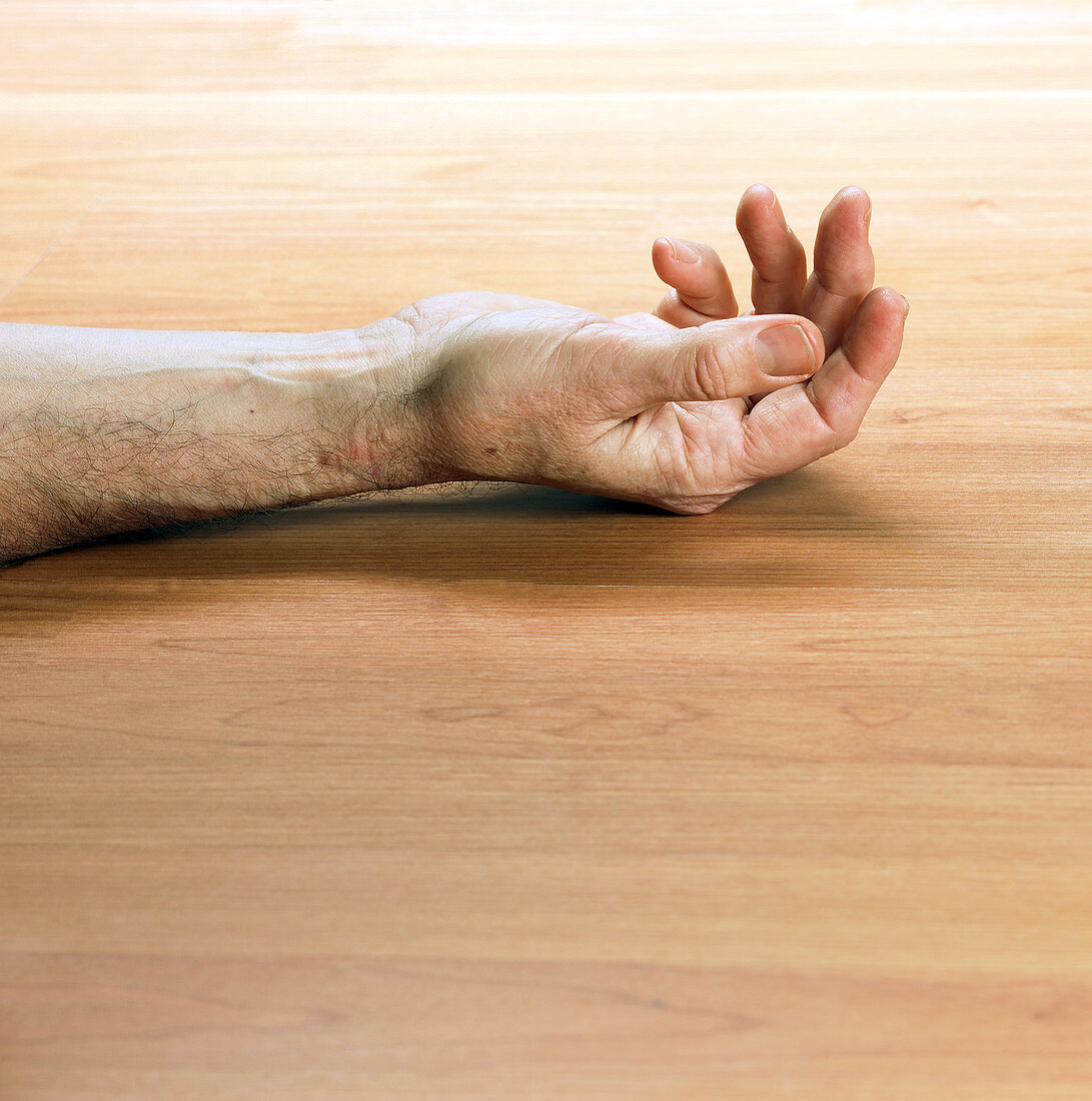 Man's arm laying on a floor
