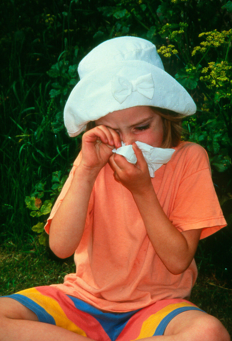 Girl with hay fever (rhinitis) blows her nose