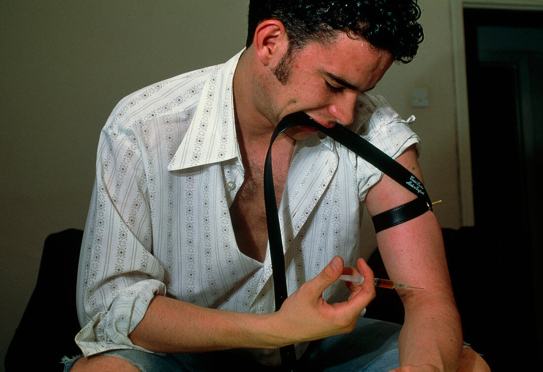 Heroin user about to inject the drug into his arm