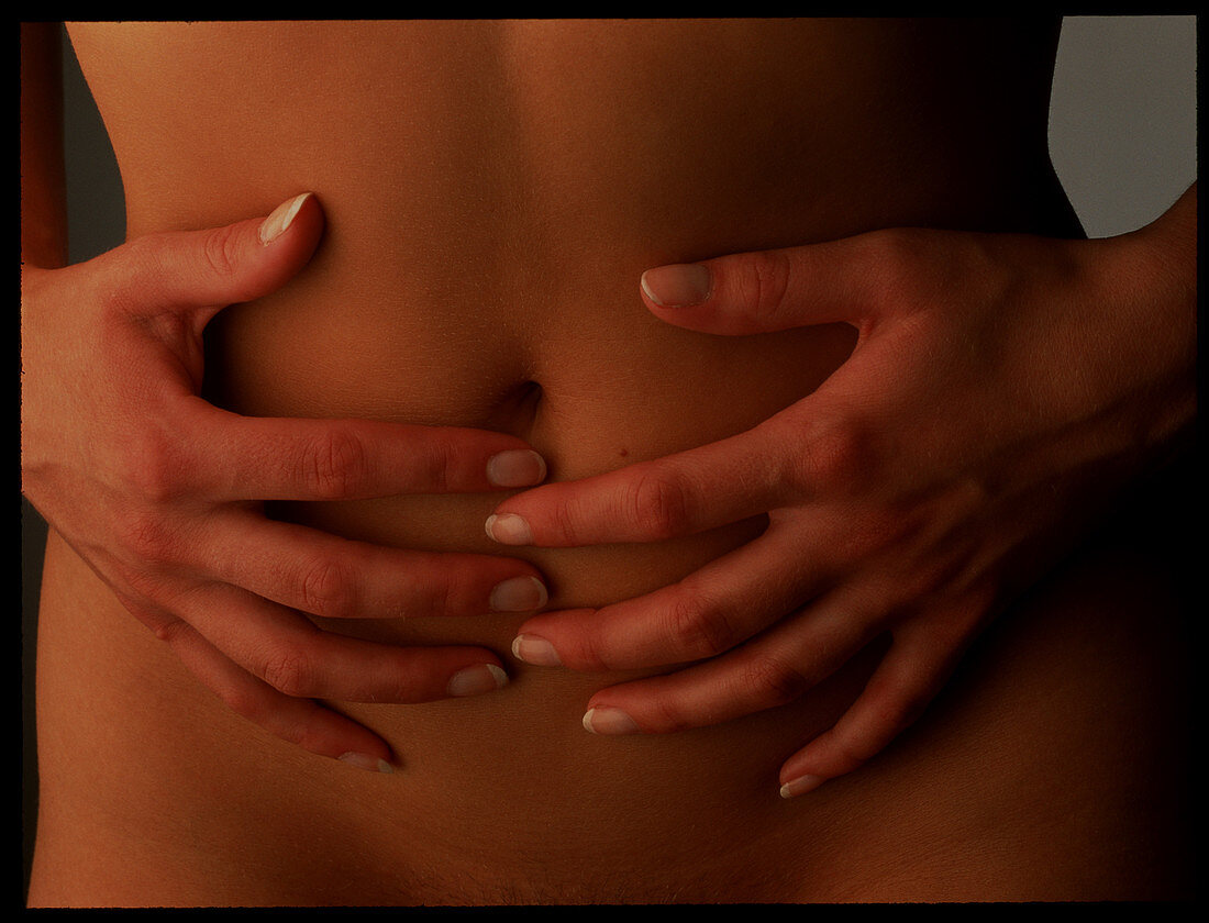 Menstrual pain: woman's hands holding her abdomen