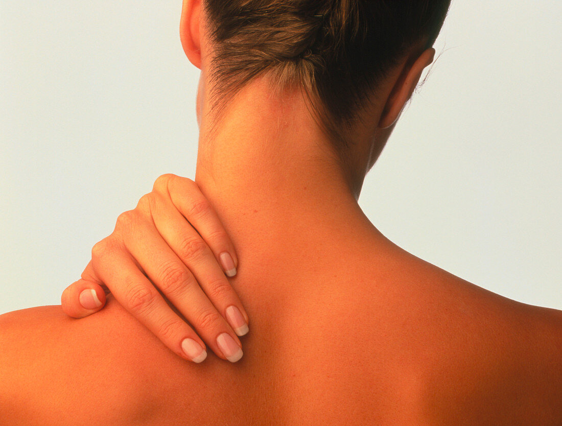 Neck pain: hand of a woman holding her neck