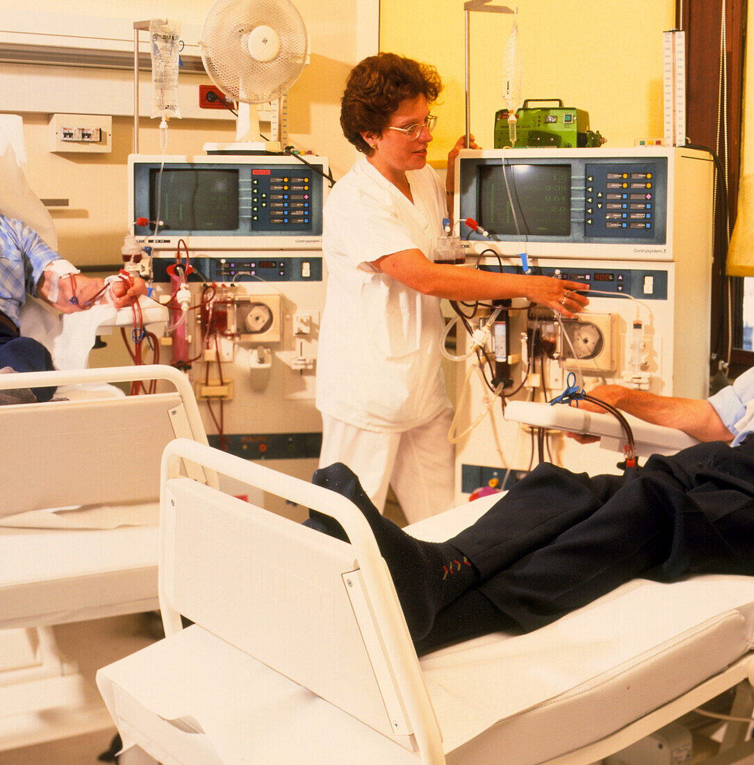 Nurse assists men during kidney dialysis