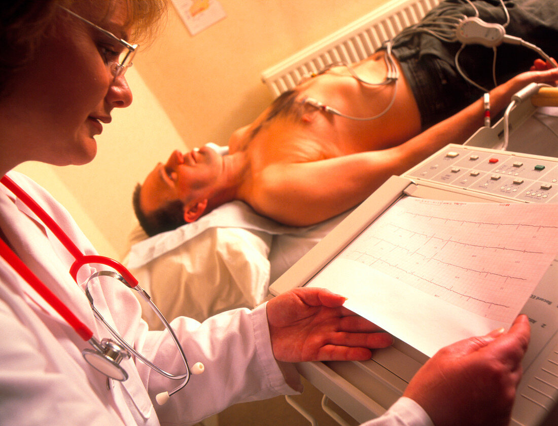 Doctor examines a male patient's ECG trace