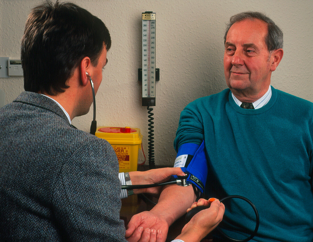 GP doctor measures blood pressure of elderly man