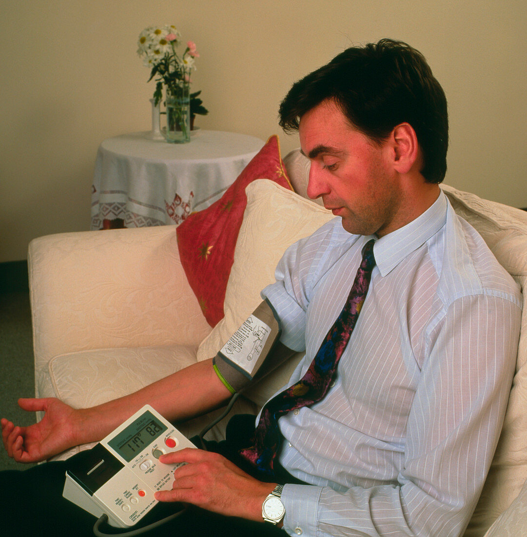 Man measures own blood pressure with digital sphy