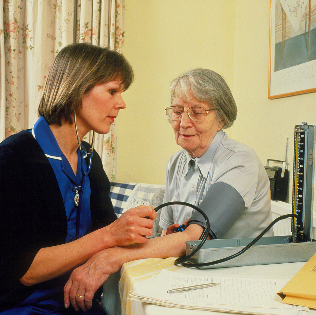 District nurse takes blood pressure of old woman