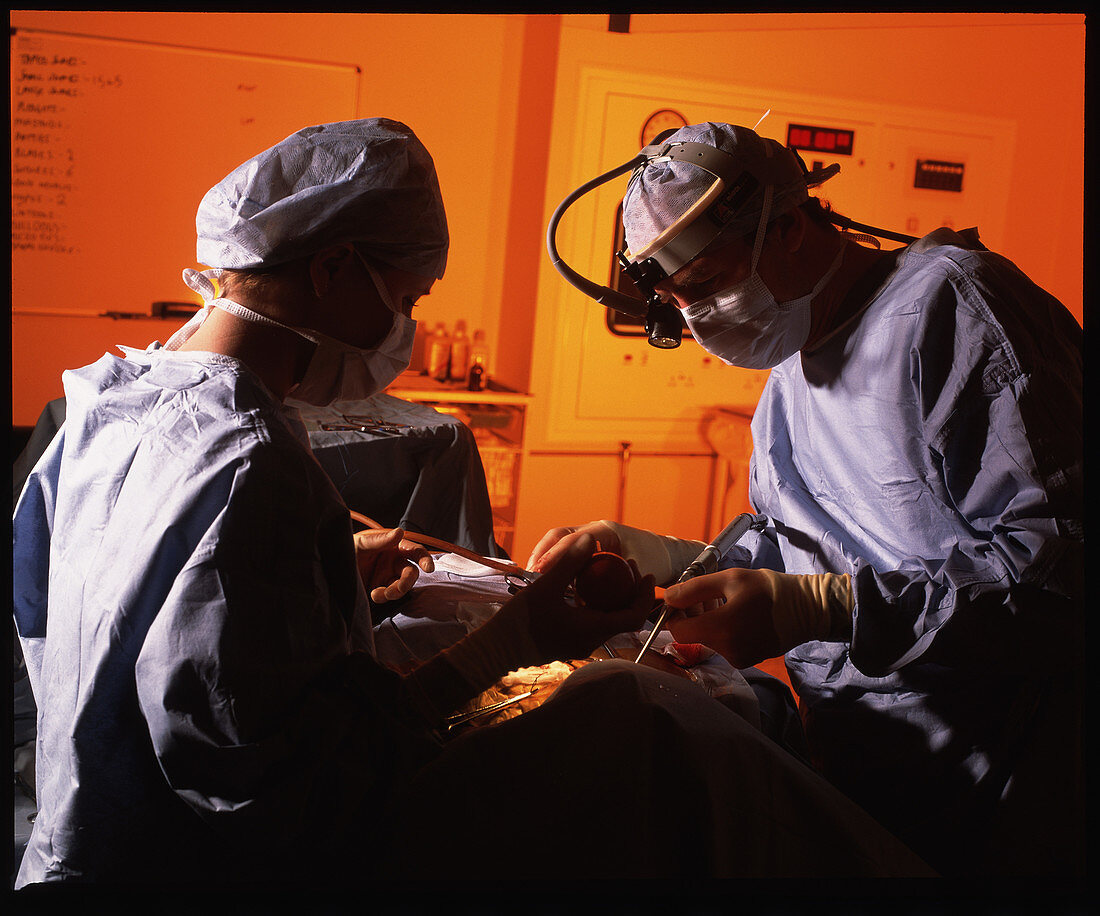 Masked surgeons conduct a surgical operation