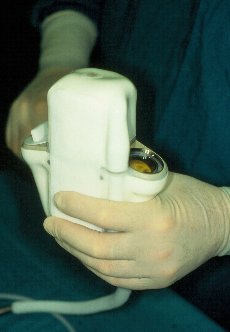Gloved hands holding a Novacor artificial heart
